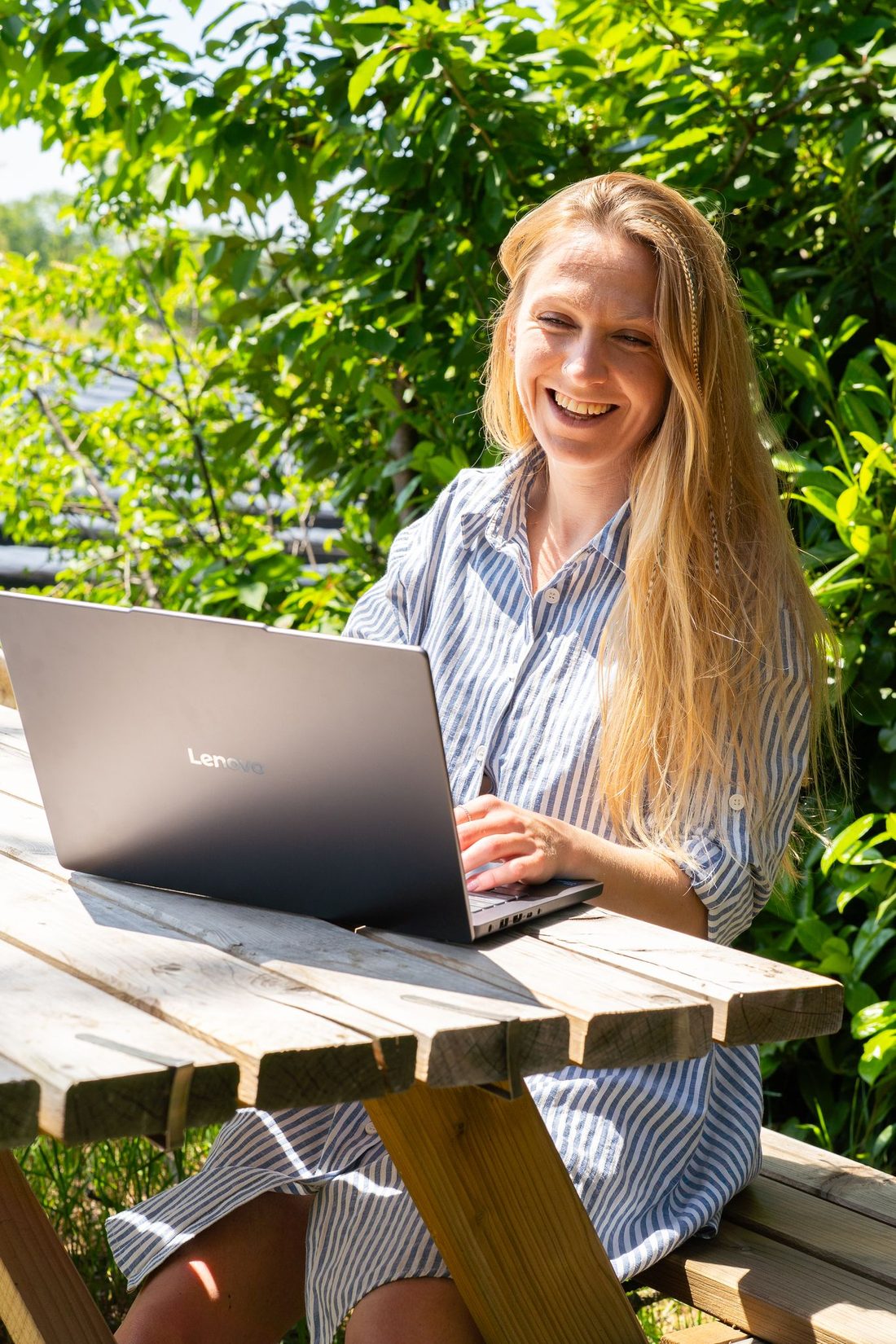 Anne lachend achter haar laptop